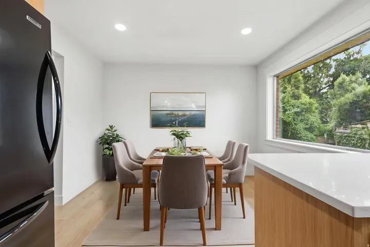 Dining area featuring a large picture window, recessed lighting, wood-finish flooring, and white walls