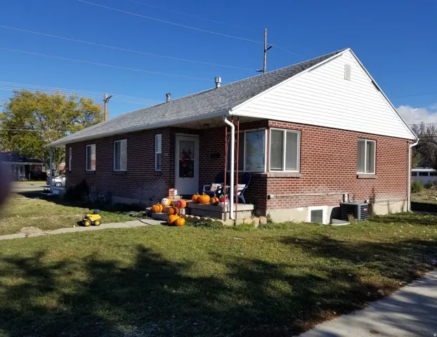 Brick exterior with white siding accents and a gray shingle roof