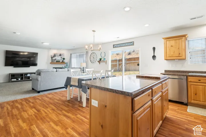 Kitchen island with a light wood finish, granite-style countertop, and integrated electrical outlets