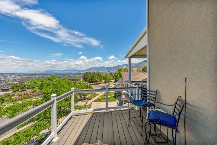 Outdoor deck featuring composite decking, cable railing, and a covered patio area