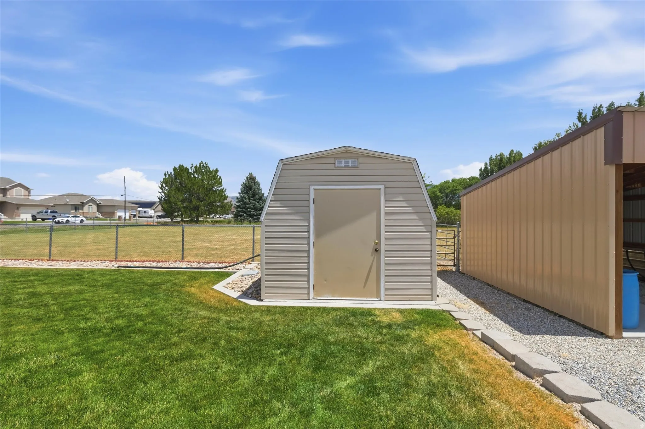 Gable roof storage shed with neutral tone siding and a full-size entry door