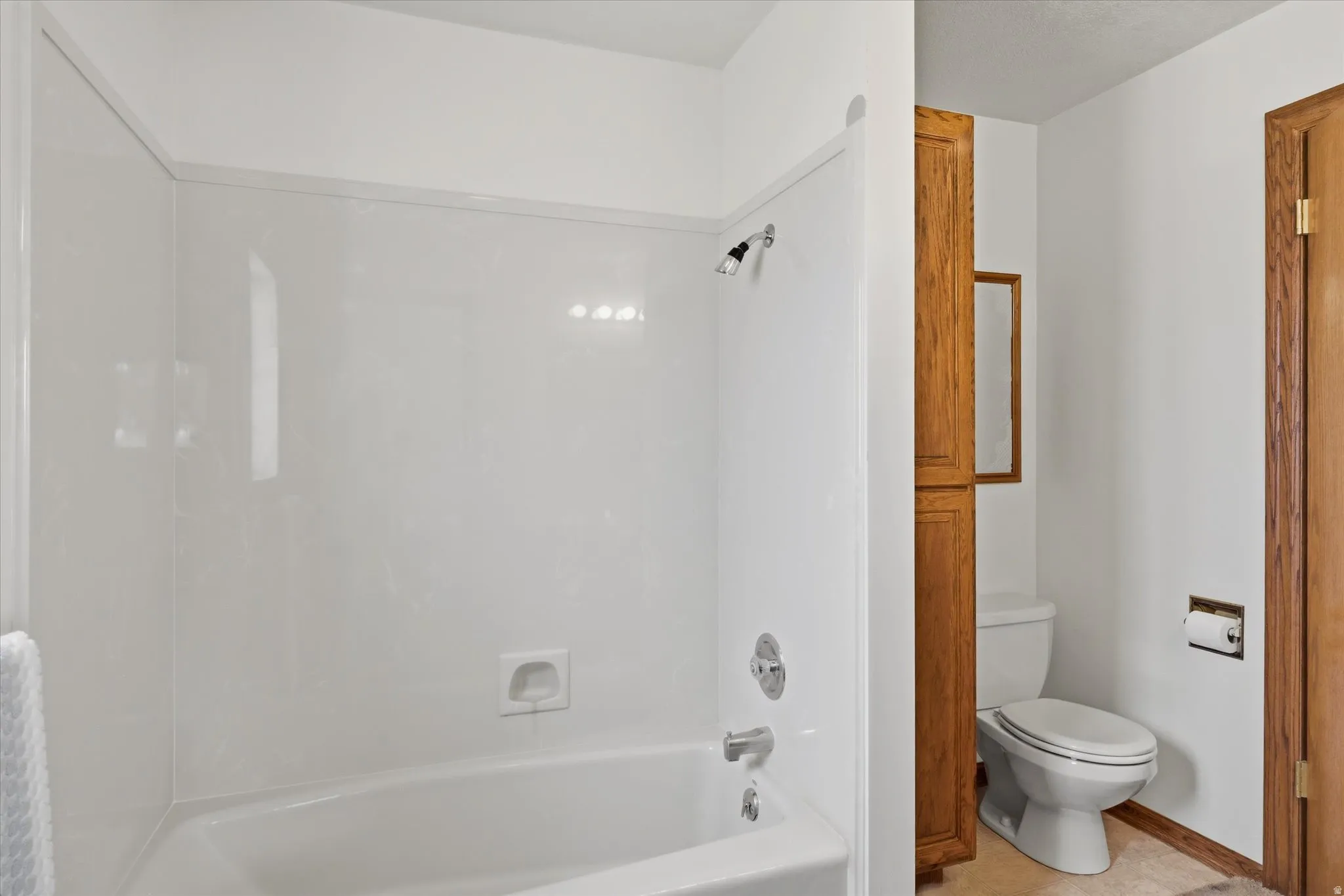 Bathroom featuring a white tub and shower combination with a single-handle faucet and shower head
