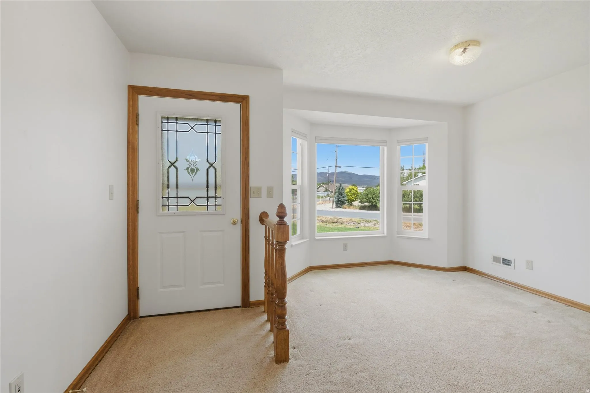 Entryway featuring a decorative glass paneled door and wood-finish trim