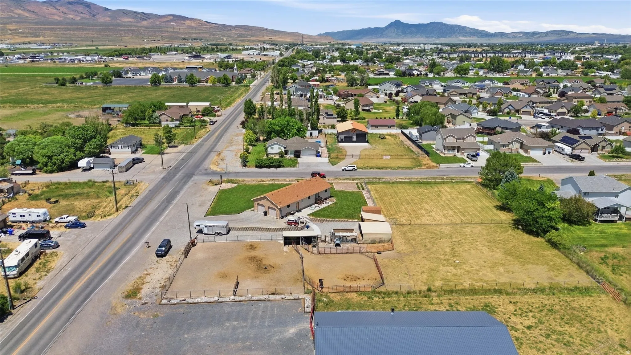 Expansive property featuring a single-story residence with an attached garage, multiple outbuildings, and extensive undeveloped land