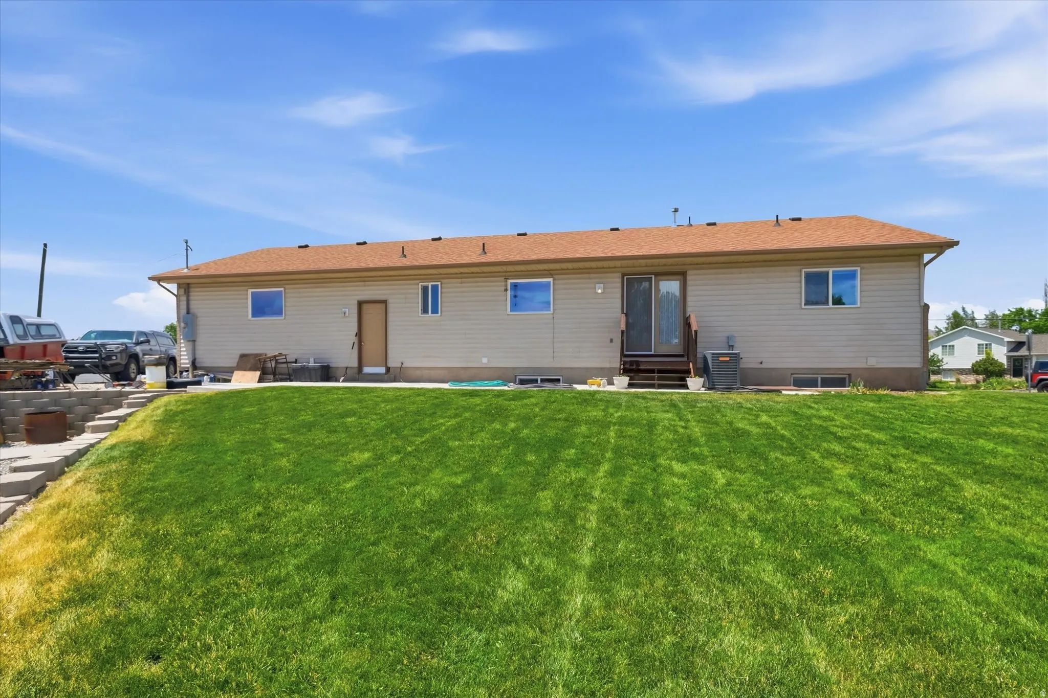 Expansive rear yard featuring a large sloped lawn