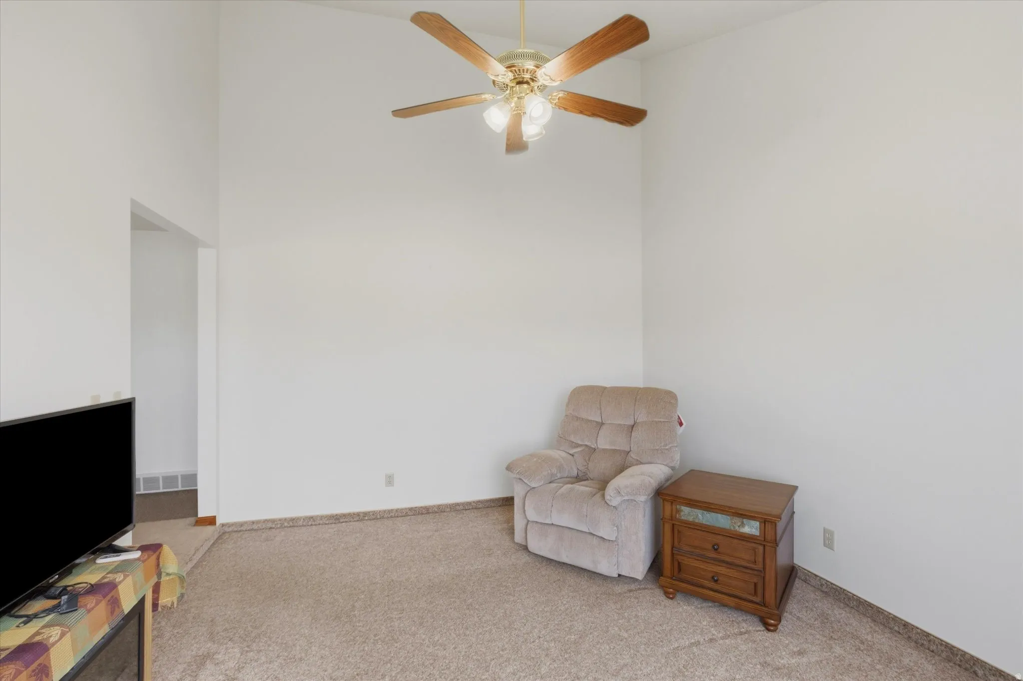 Vaulted ceilings featuring a ceiling fan with light fixture