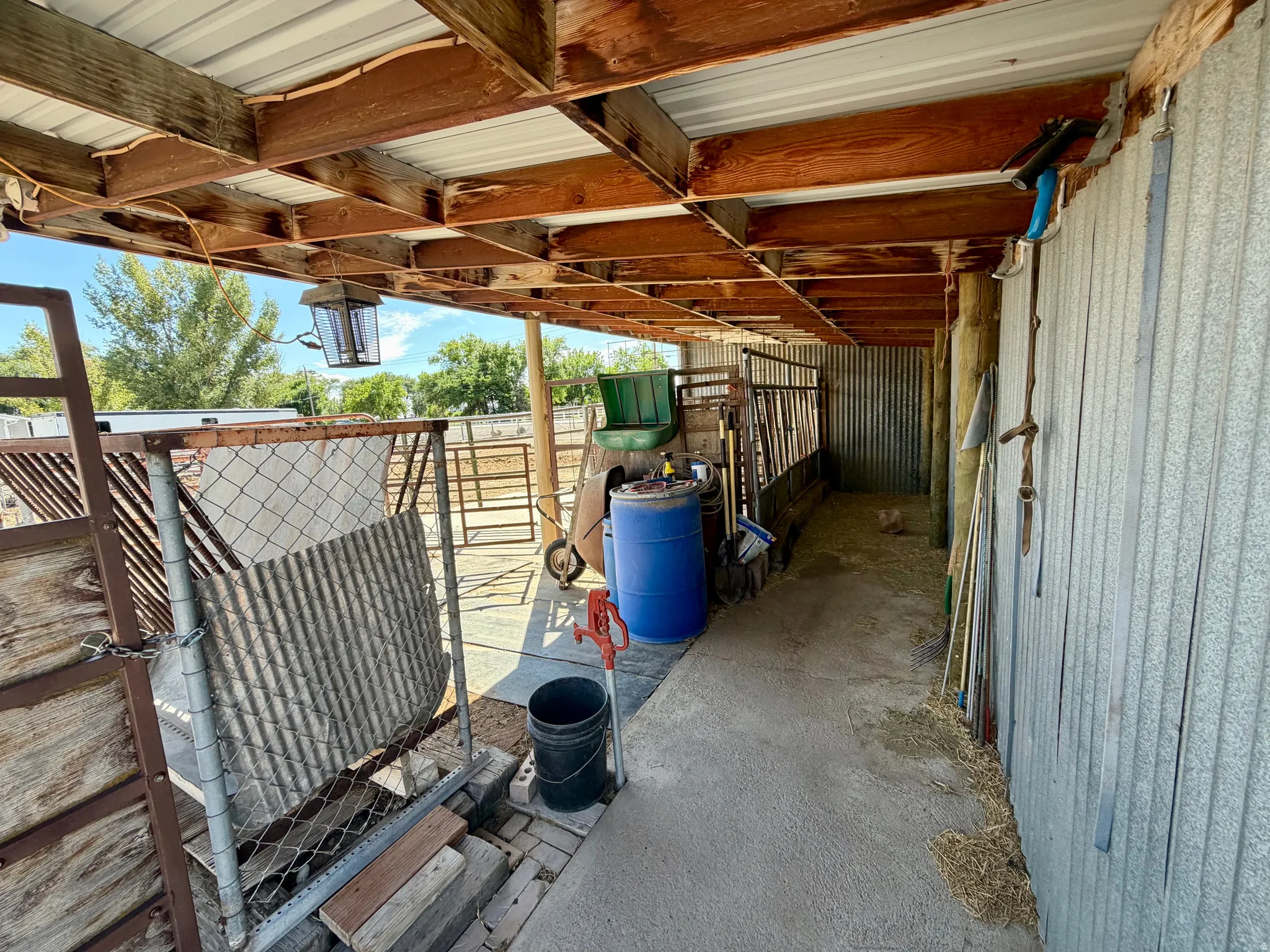 Covered outdoor area with exposed wooden beams and a corrugated metal roof