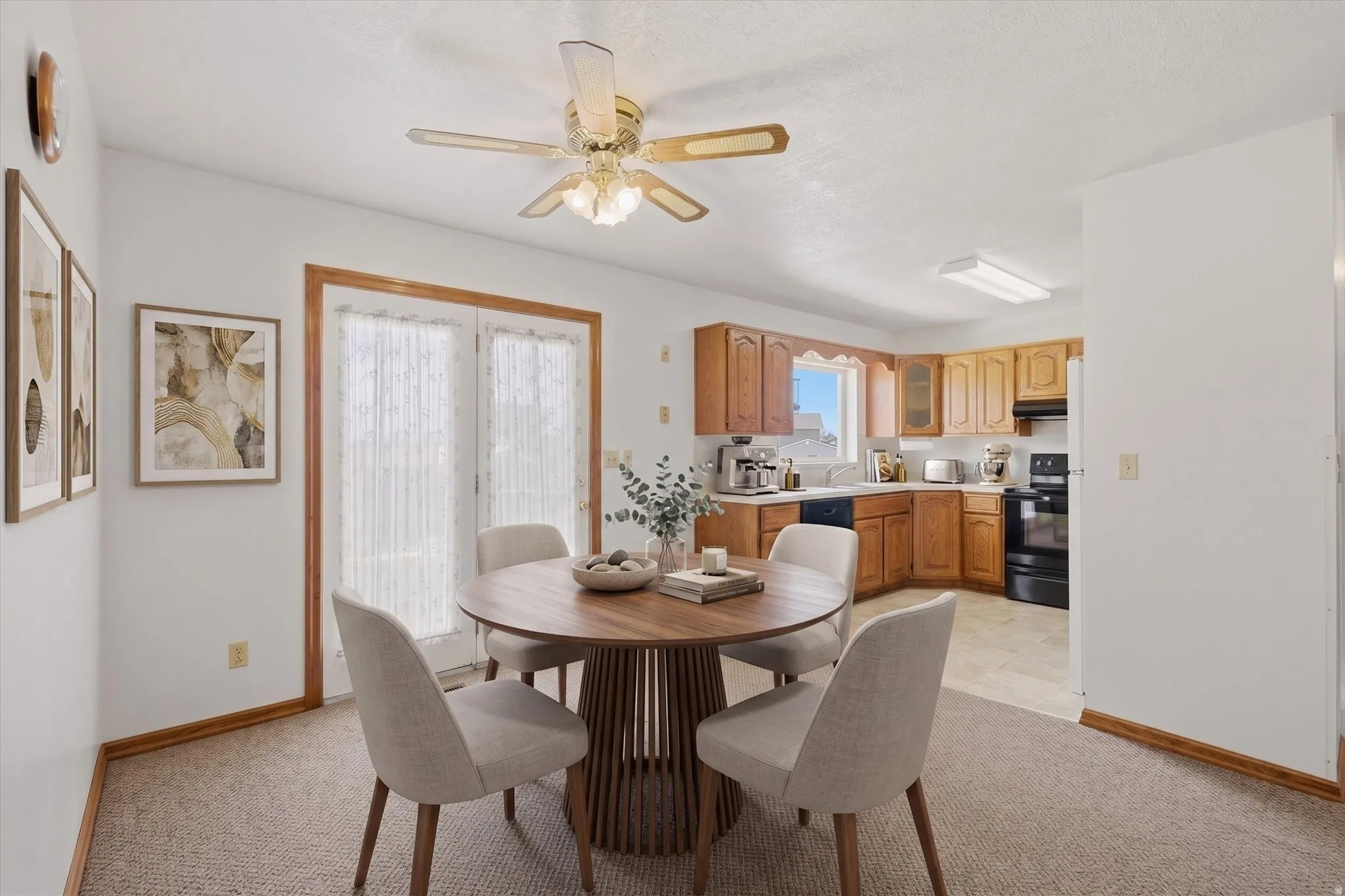 Dining area with light-toned carpet flooring and a ceiling fan
