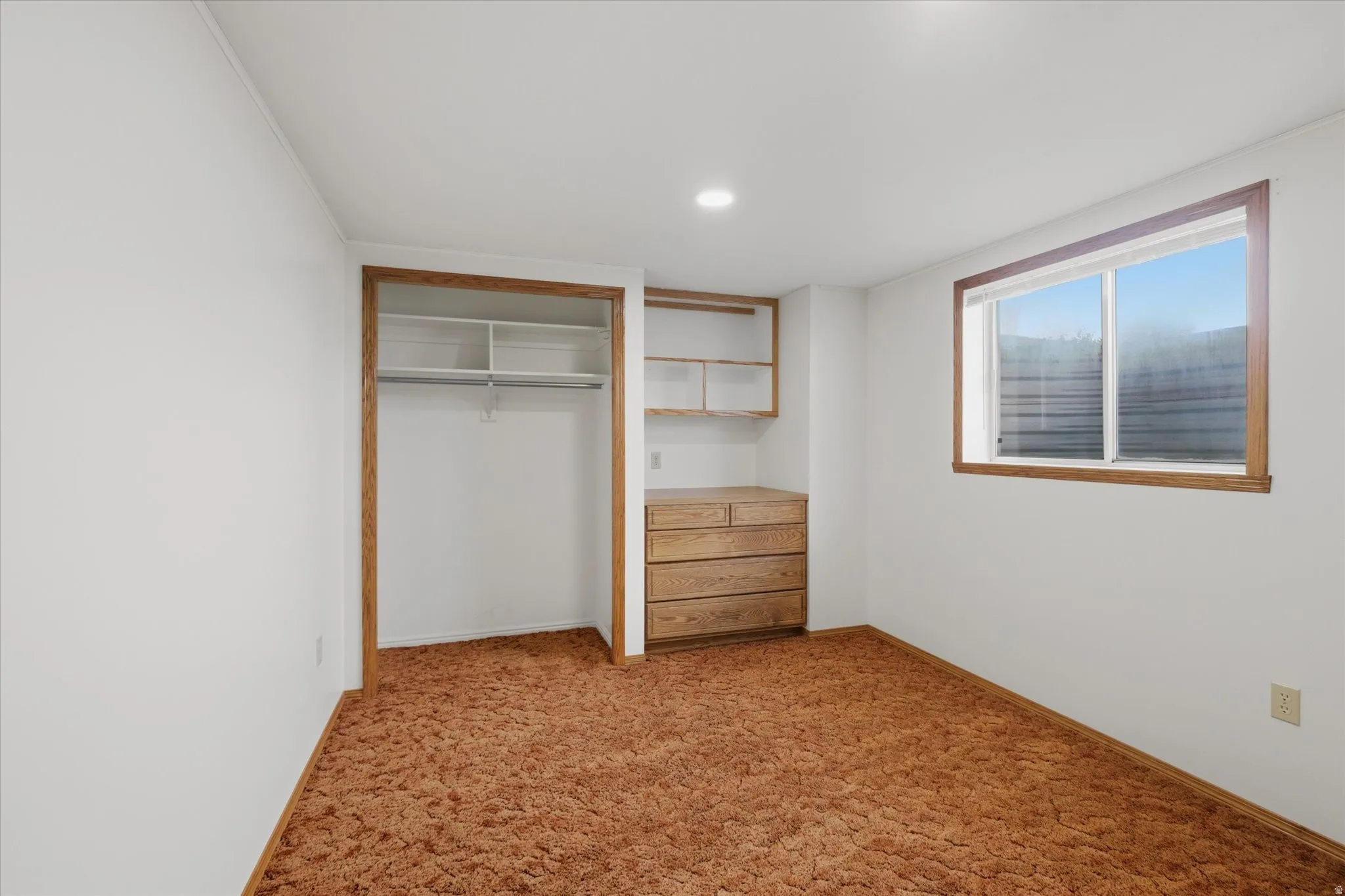 Room featuring built-in storage with a wardrobe rod, shelving, and a dresser unit