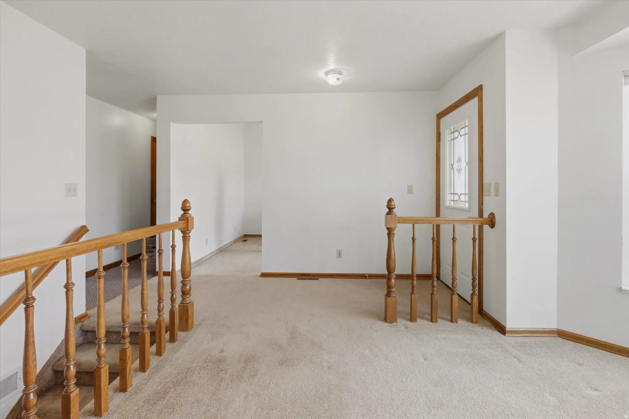 Front entryway featuring a white paneled door with decorative glass inserts and wood trim