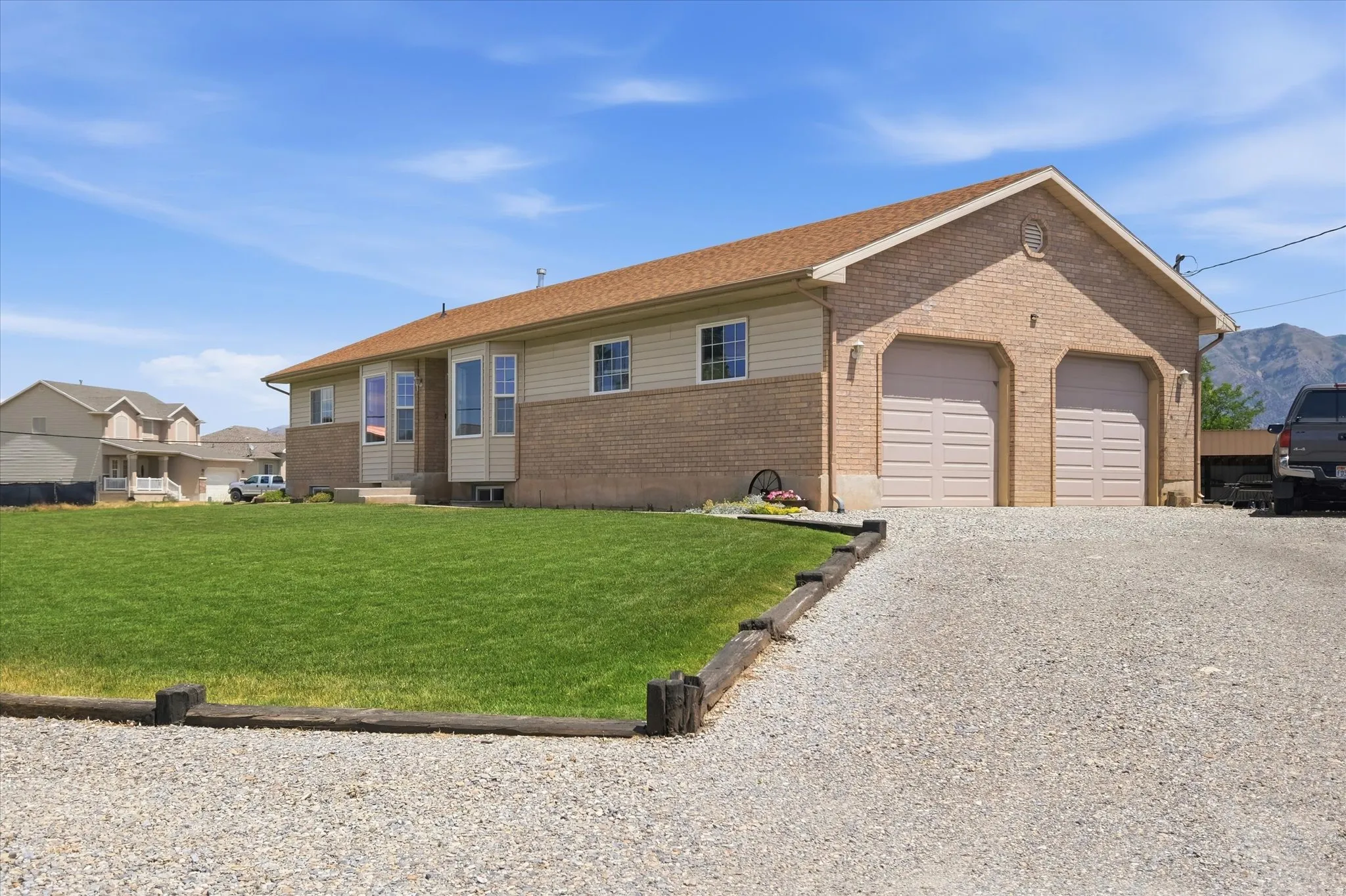 Beige brick and siding exterior with a brown shingle roof