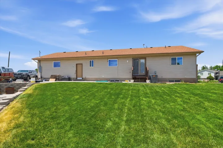Expansive rear yard featuring a large sloped lawn