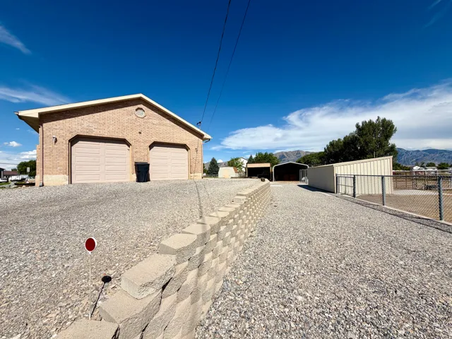 Brick exterior structure featuring two garage bays and a gravel driveway