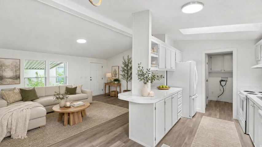 Bright interior featuring wood-finish flooring throughout, a vaulted ceiling, and white walls