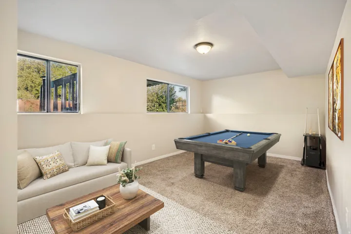 Virtually staged Finished basement area featuring warm neutral wall tones and a ceiling-mounted light fixture
