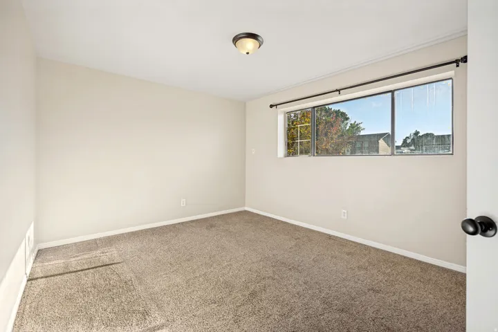 Neutral-toned walls complement plush carpeting