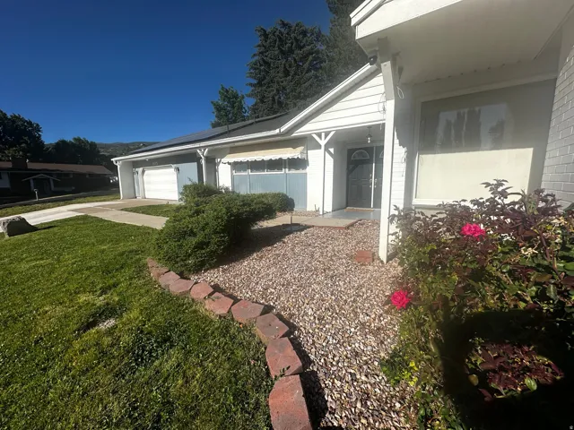 Ranch-style exterior with a dual garage, a covered entry, and a gravel and shrub landscaping bed