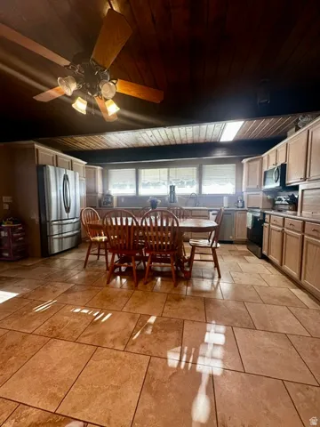 Spacious kitchen featuring extensive cabinetry, stainless steel appliances, and a wood-finish plank ceiling