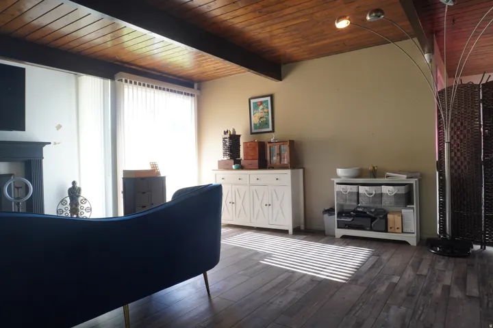 Living area featuring wood-finish flooring, a wood plank and beam ceiling, and ample natural light from large windows
