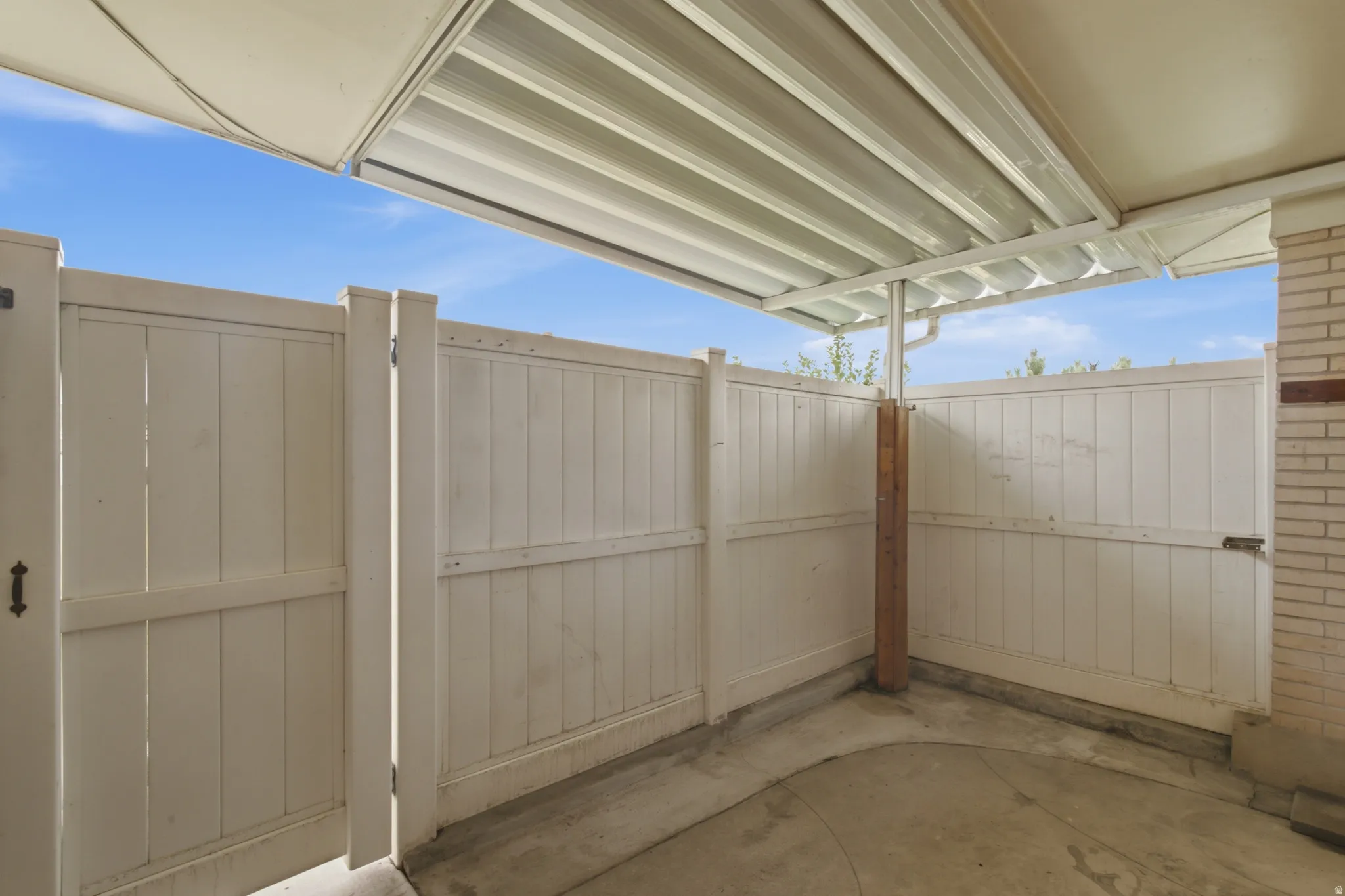 Covered outdoor patio area featuring concrete flooring
