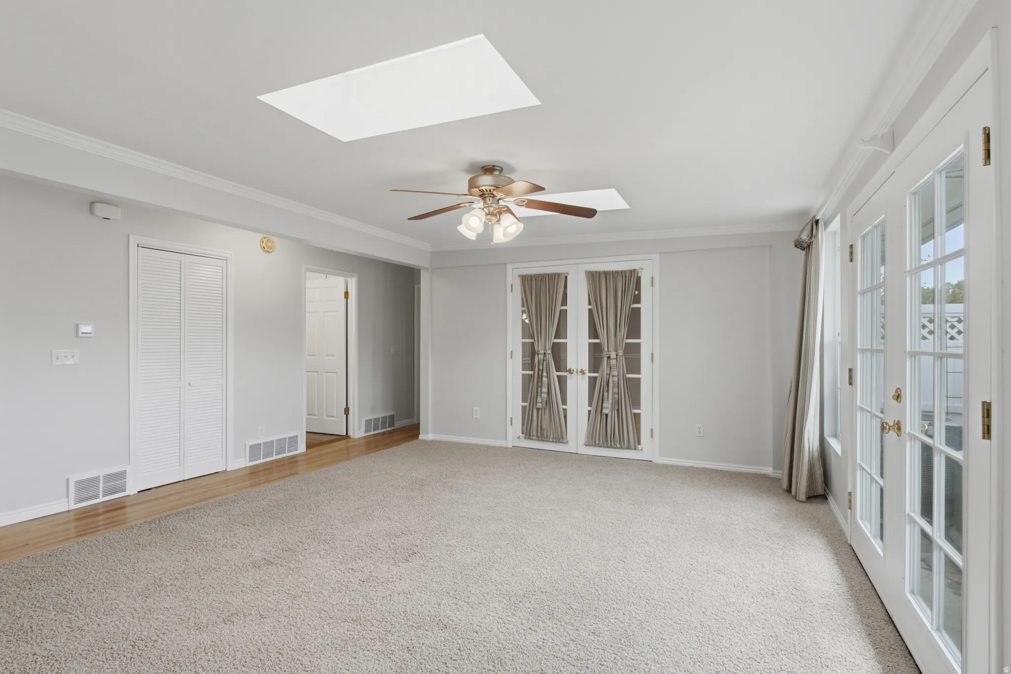 Spacious living area featuring neutral carpeting and light gray wall paint