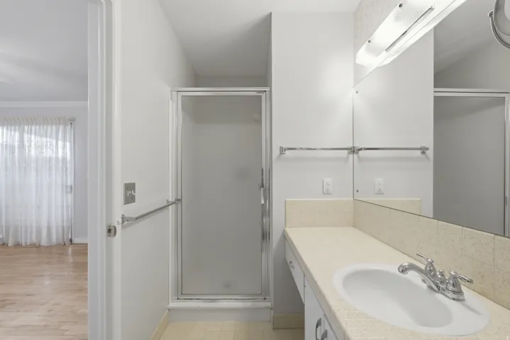 Bathroom featuring an elongated vanity with an integrated sink, chrome faucet, and a large mirror