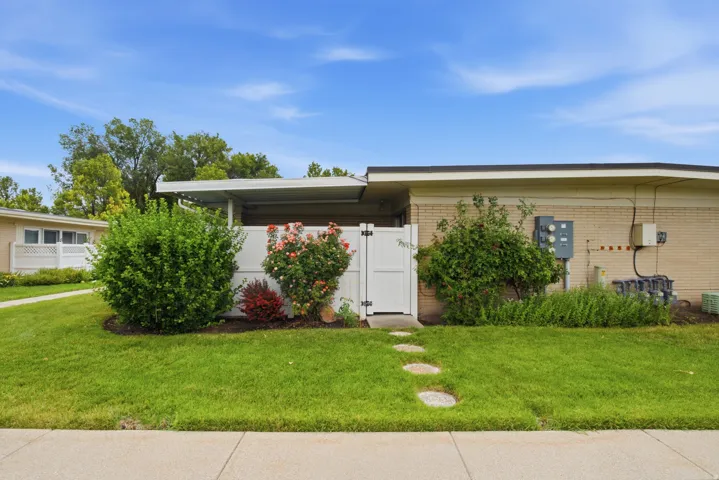Manicured lawn with stepping stones leading to a white privacy fence and gate