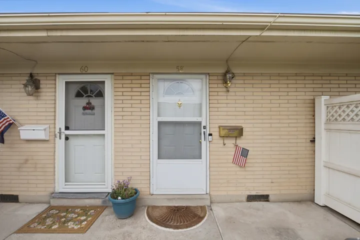 Brick exterior featuring two entry doors with storm doors, each with a decorative glass insert