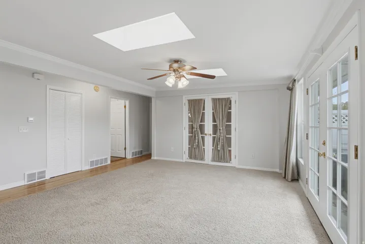 Spacious living area featuring neutral carpeting and light gray wall paint