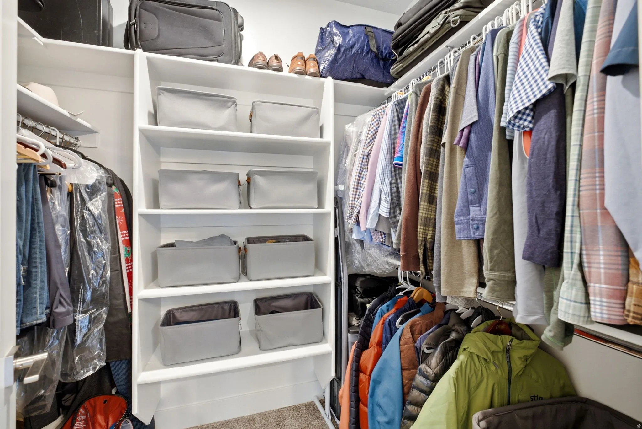 Custom closet system featuring multiple levels of hanging rods and integrated shelving units