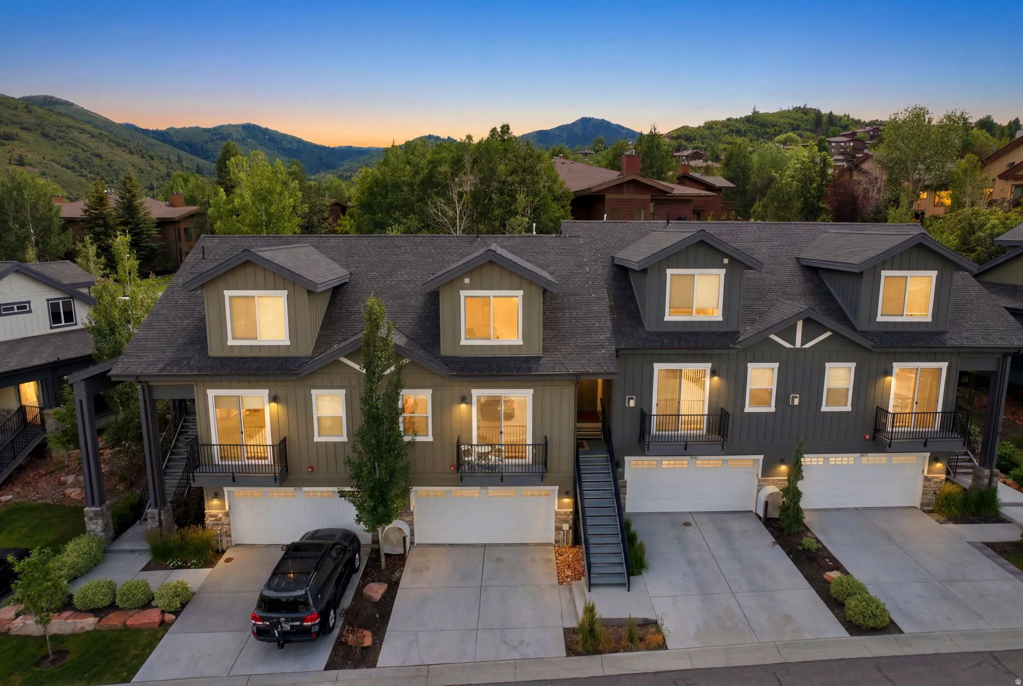 Contemporary townhome exteriors featuring dormer windows, individual garages, and private balconies