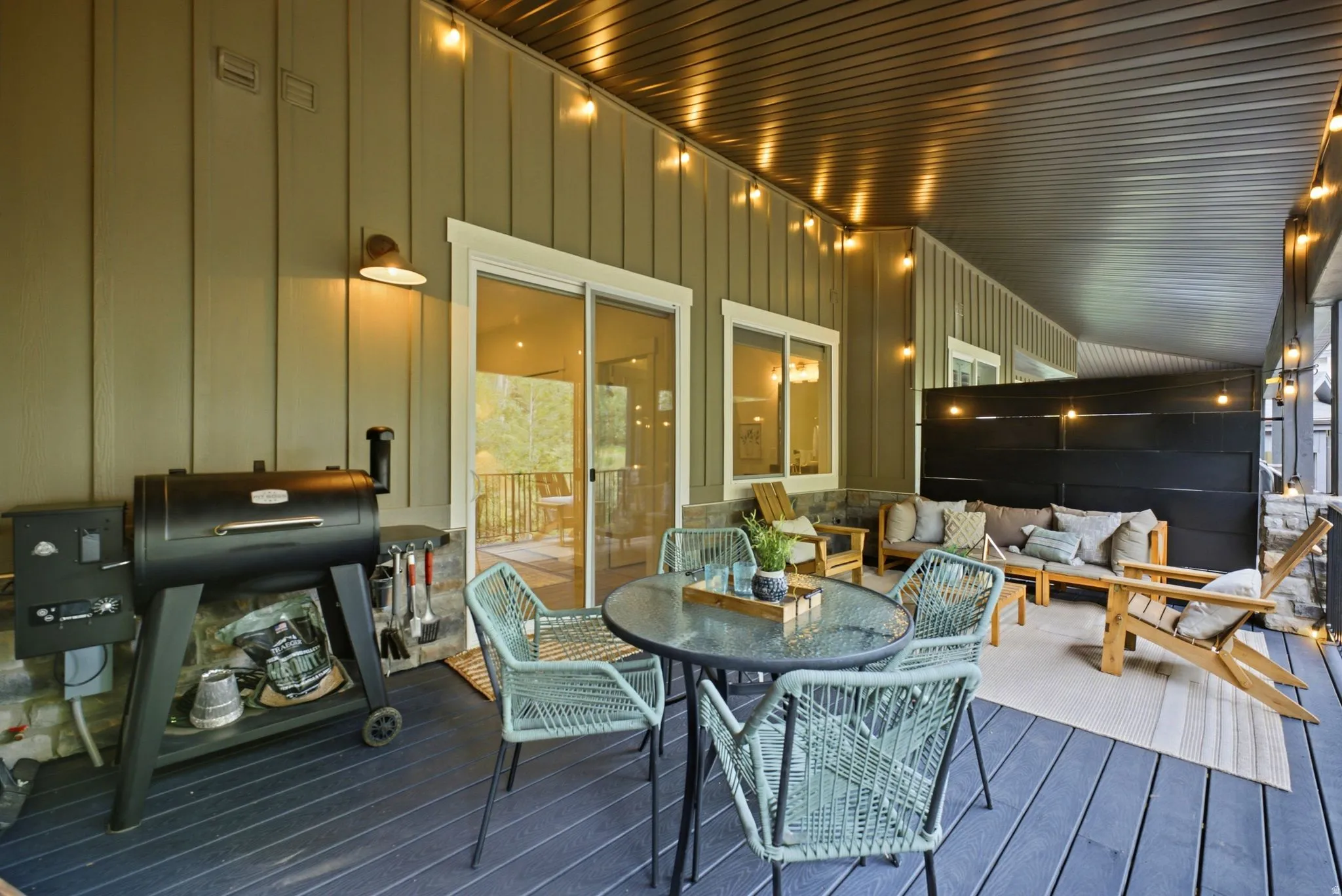 Expansive covered patio featuring a dark-stained deck, beadboard siding, and recessed lighting