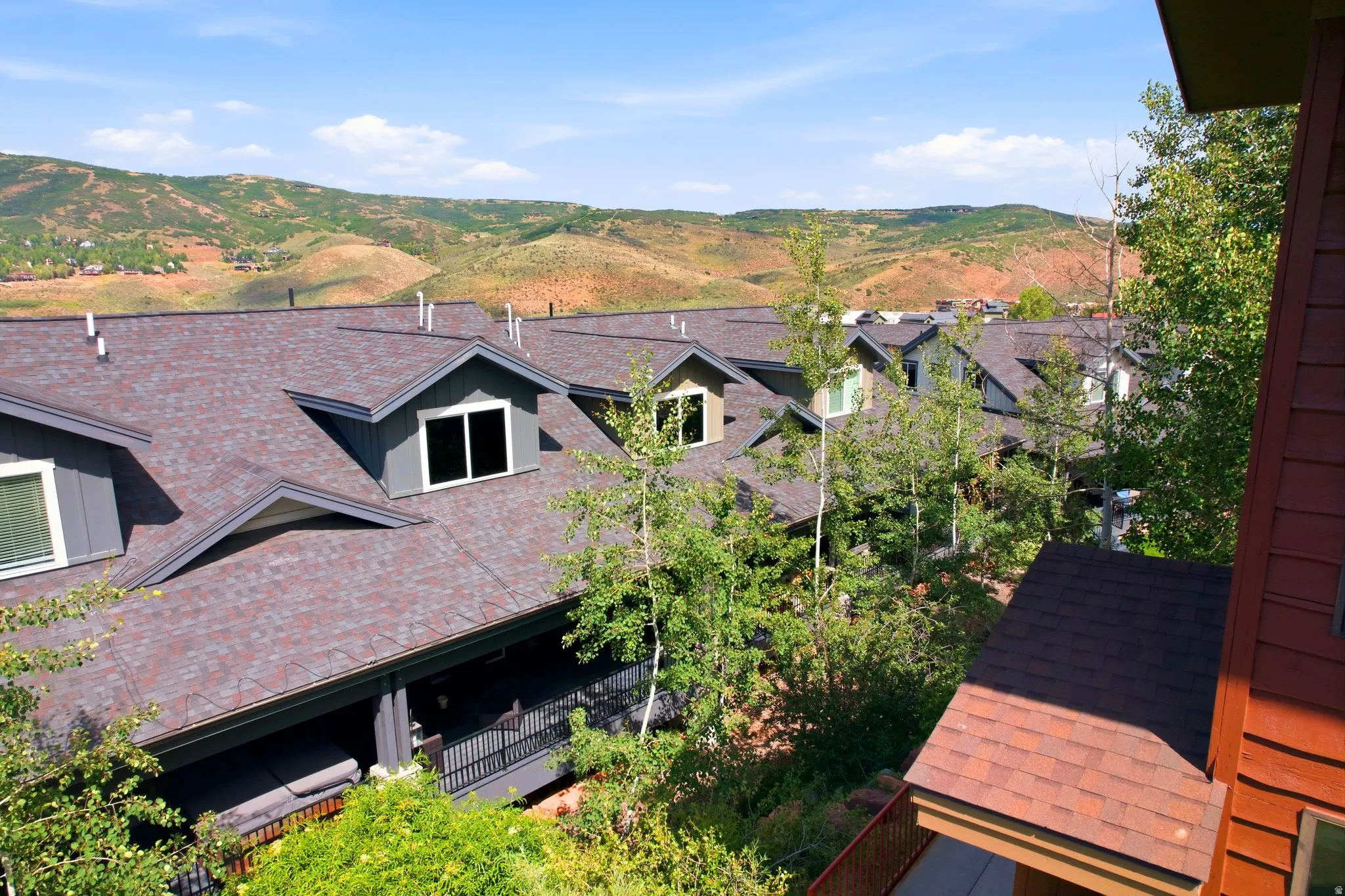 Gabled roofs featuring dormer windows and dark shingles
