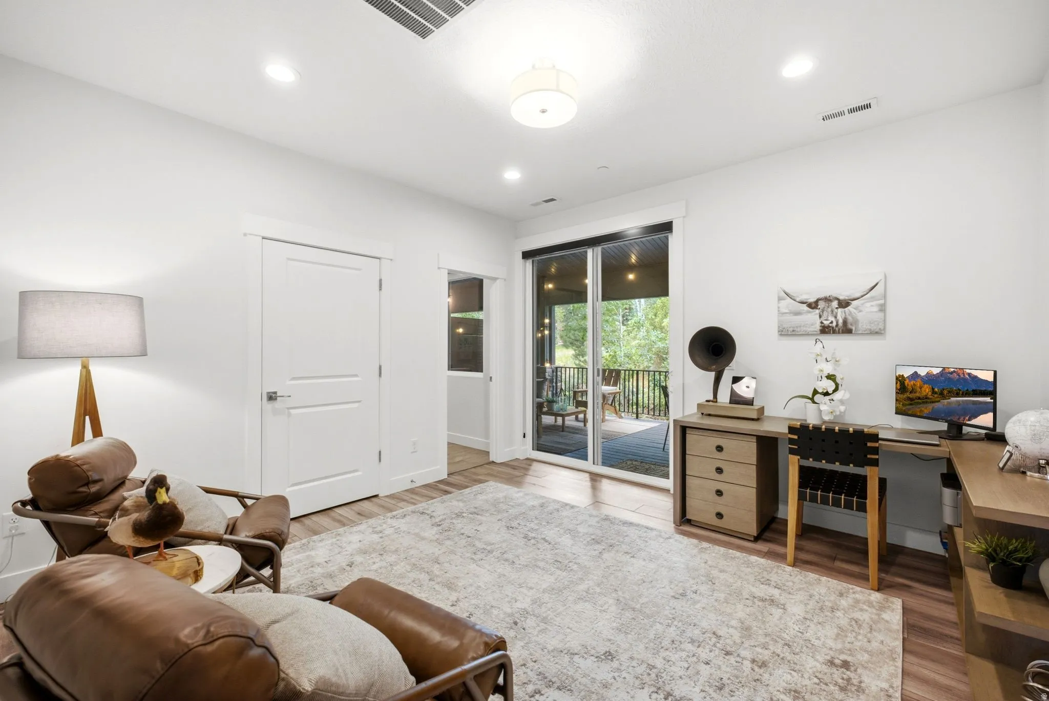 Bright interior space featuring wood-finish flooring and a glass sliding door leading to an outdoor deck