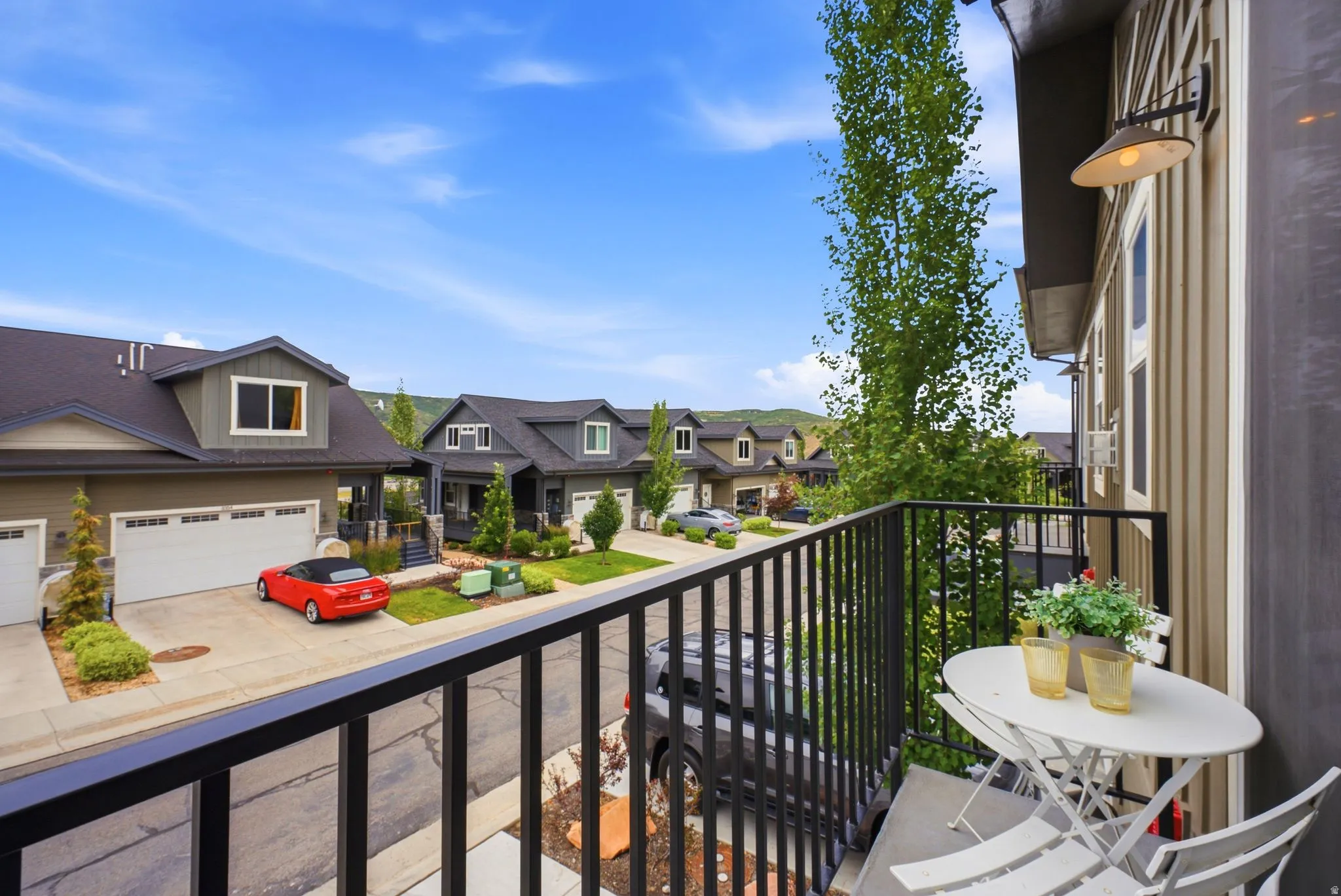 Private balcony featuring a black metal railing and exterior wall sconce