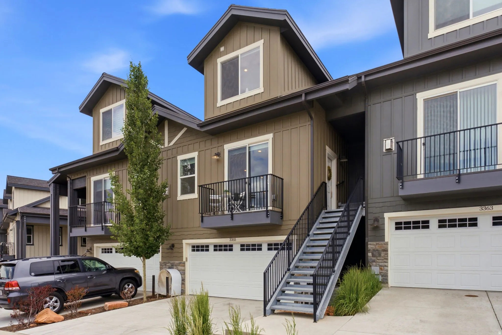 Townhome-style residence featuring vertical siding and stone accents