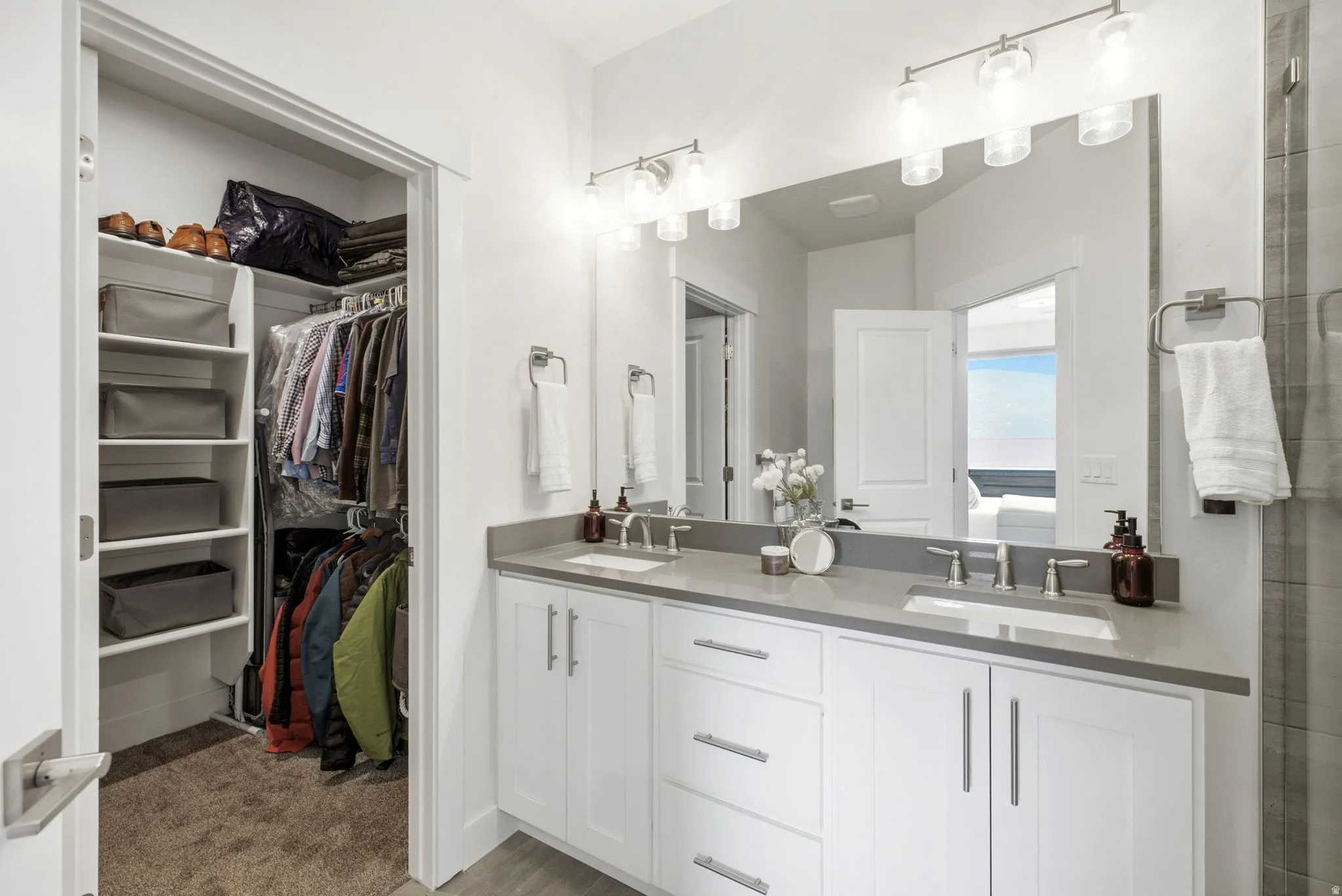 Double vanity featuring white cabinetry, grey countertops, and undermount sinks