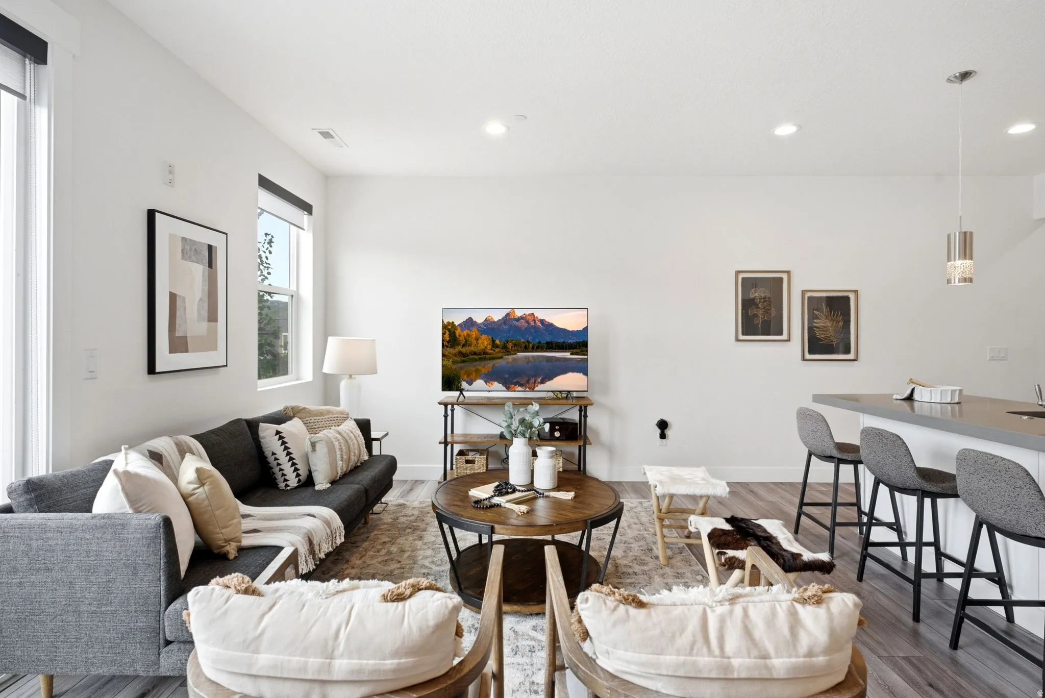 Open-concept living area featuring light wood-finish flooring, recessed lighting, and a white color palette