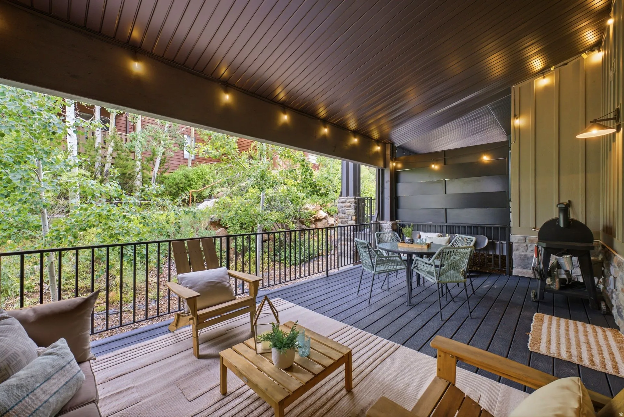 Spacious covered outdoor deck with dark wood-finish flooring