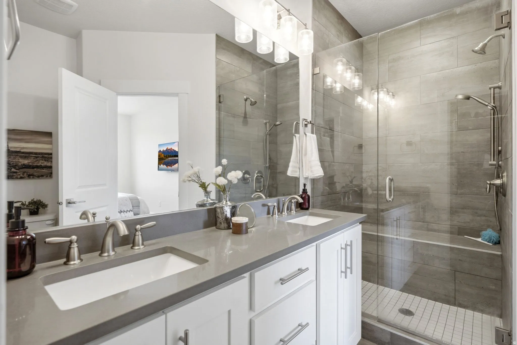Bathroom featuring a double vanity with grey countertops, dual undermount sinks, and brushed nickel fixtures