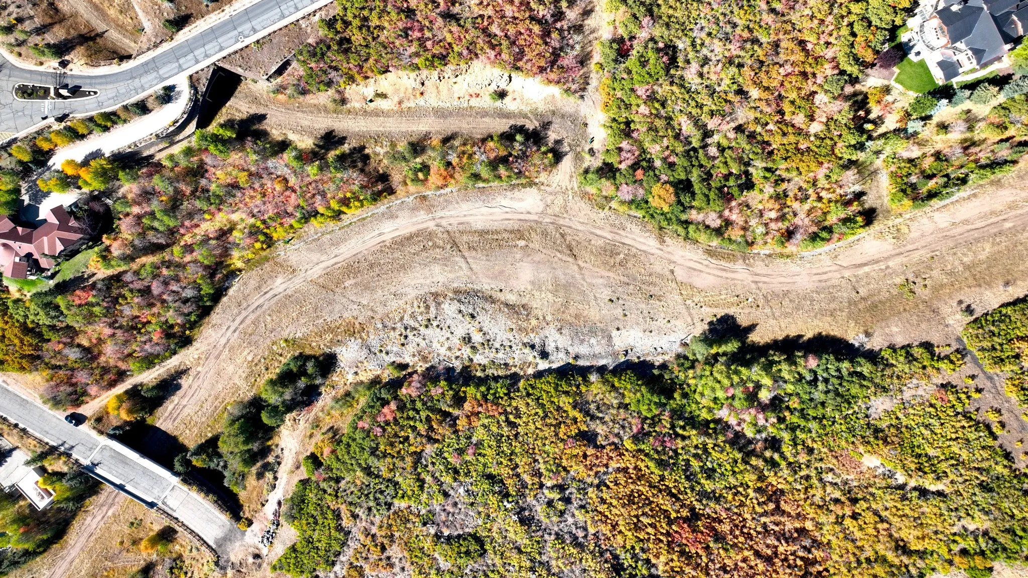 Aerial perspective of a developing land parcel, featuring varied topography and natural vegetation