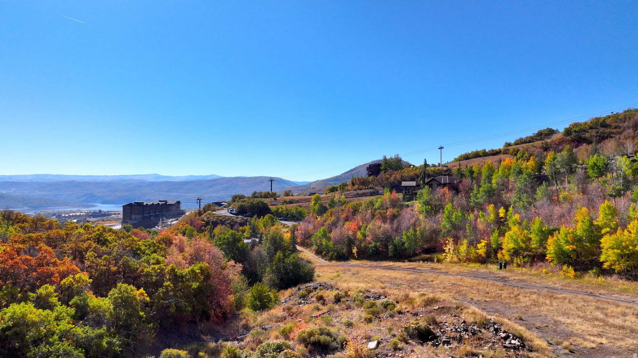 Expansive mountain landscape featuring vibrant autumn foliage and distant mountain ranges