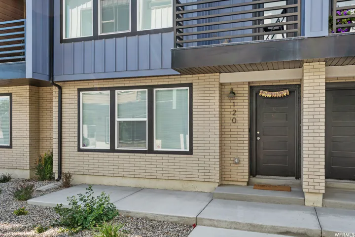 Multi-level exterior featuring light-colored brick and vertical blue siding