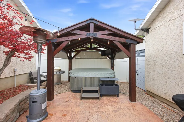 Outdoor spa area featuring a wooden gazebo with integrated lighting