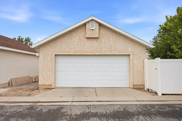 Single-bay garage featuring a stucco exterior and white overhead door