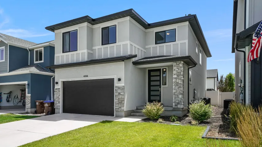 Contemporary stucco exterior with stone accents and dark trim