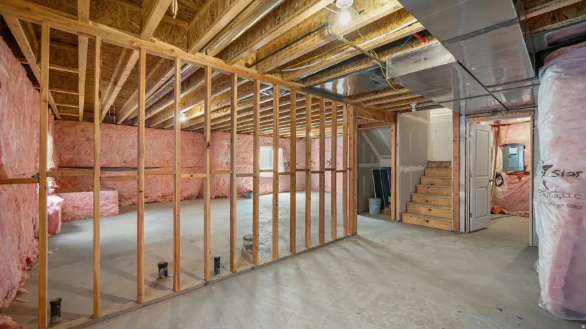 Unfinished basement featuring exposed wood framing, concrete flooring, and extensive wall insulation