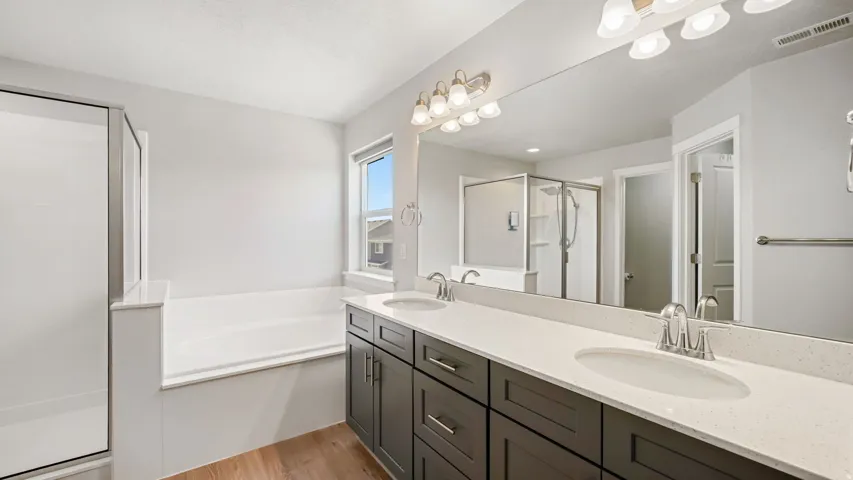 Bathroom featuring a double vanity with dark wood-finish cabinetry, light-colored countertops, and two undermount sinks
