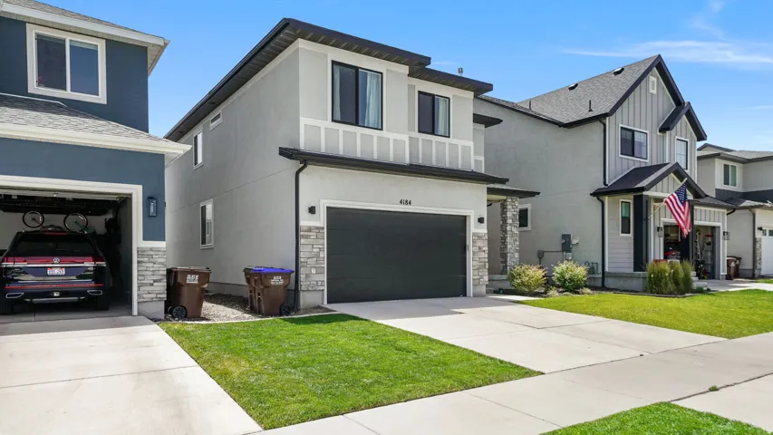 Contemporary two-story residence with a light gray stucco exterior and dark trim accents