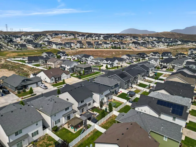 Modern residential development featuring a variety of architectural styles, paved streets, and mountain ranges in the background